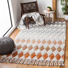 a living room area with a chair, rug and potted plant