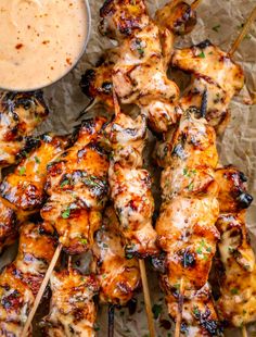 grilled chicken skewers with dipping sauce on the side