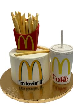 there is a cake that has french fries and a cup on it