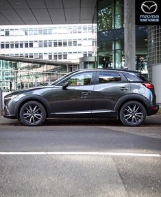 a mazda car parked in front of a building