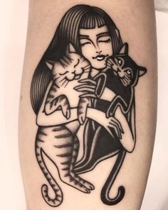 a woman holding a cat on her arm with another cat in the other arm behind her
