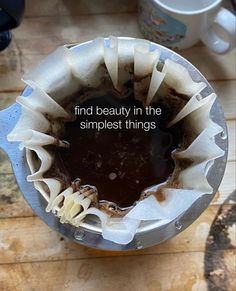 a cup filled with liquid sitting on top of a wooden table