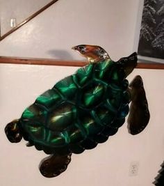 a glass turtle sitting on top of a white wall