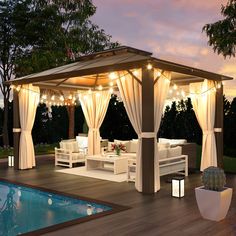 a gazebo with curtains and lights around it next to a pool