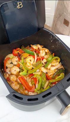 a pan filled with shrimp and peppers on top of a stove