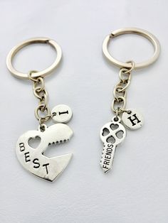 two keychains with different designs on them, one has a cat and the other has a dog's paw