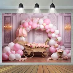 a baby's carriage with balloons and flowers on the floor in front of a backdrop