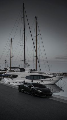 a black sports car parked in front of a boat