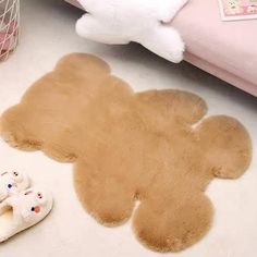 a teddy bear rug and slippers on the floor