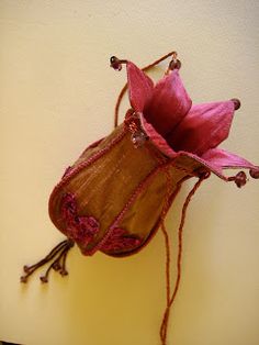 a pink flower sitting on top of a brown bag