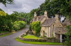 an old stone house surrounded by lush green trees