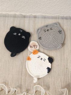 two crocheted animals are laying on a bed together, one is black and the other is white