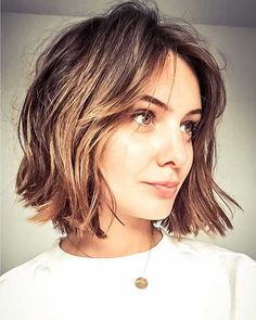 a close up of a person with a necklace on her neck and shoulder length hair