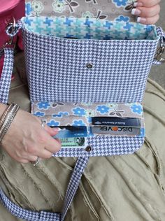 a woman is sitting on the ground with her purse in her lap and holding it open