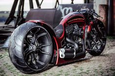 a red motorcycle parked on top of a dirt field