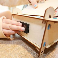 a child playing with a wooden toy house