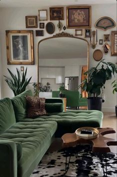 a living room with green couches and pictures on the wall above it's mirror