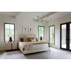 a bedroom with white furniture and large windows