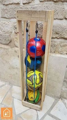 several balls in a wooden box on the ground