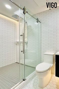 a white toilet sitting next to a walk in shower