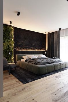 a large bed sitting on top of a wooden floor next to a wall mounted plant