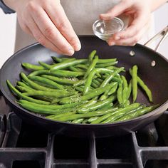 a person cooking green beans in a pan