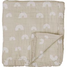 a blanket with white rainbows on it and a beige sheet that has been folded over