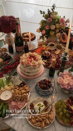 a table filled with lots of different types of food and wine bottles on top of it