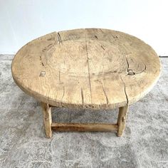 a round wooden table sitting on top of a carpeted floor