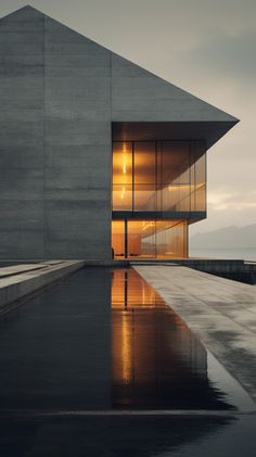 the building is made out of concrete and has a large pool in front of it