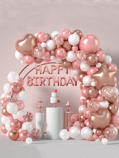 a pink and white birthday arch with balloons