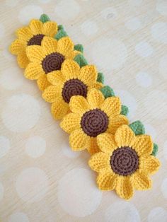 crocheted sunflowers are arranged on a table