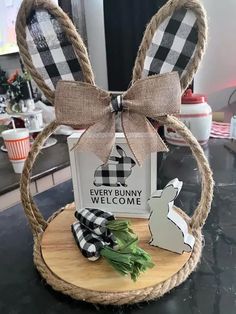 an easter bunny welcome sign on a wooden stand with a bow around it's ears