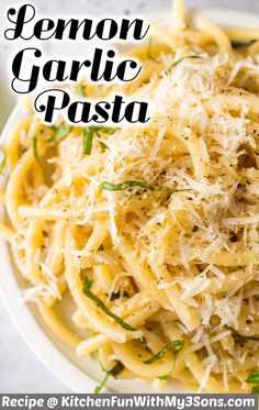 a white plate topped with pasta covered in parmesan cheese and garnished with herbs