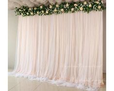 the backdrop is decorated with white flowers and greenery