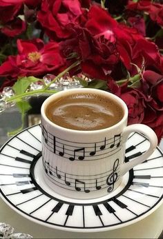 a cup of coffee sitting on top of a saucer with music notes painted on it