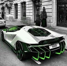 a white and green sports car parked in front of a building on a city street