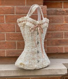 a white purse sitting on top of a brick wall