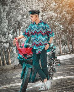 a man standing next to a motorcycle with trees in the background