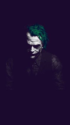 the joker with green hair is looking at his cell phone