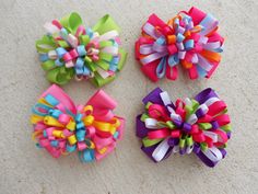 four colorful hair bows laying on the ground