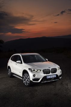 a white bmw suv parked in the dark