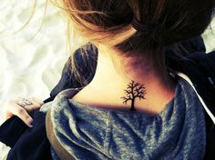 a woman with a small tree tattoo on her neck and back side ribcage