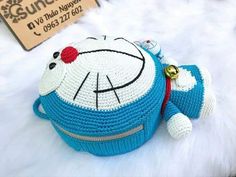 a crocheted hello kitty purse sitting on top of a white fur covered floor
