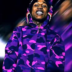 a man wearing a purple camo hoodie with his mouth open and tongue out