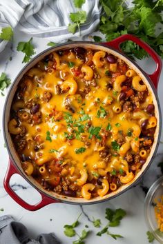 a red pot filled with chili macaroni and cheese