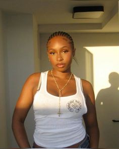 a woman in a white tank top is posing for the camera