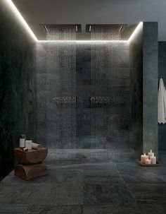 a large shower in a bathroom next to candles