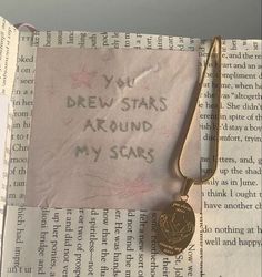 a close up of a piece of paper with writing on it and a gold necklace