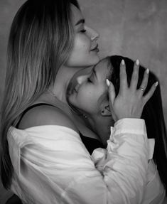 two women are hugging each other in black and white